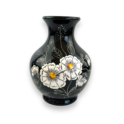 Large black vase with white and yellow flower artwork